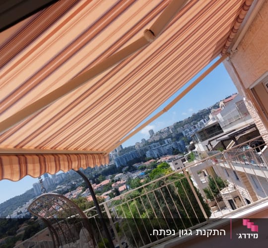 סוכך בד פסים כתום ולבן במרפסת